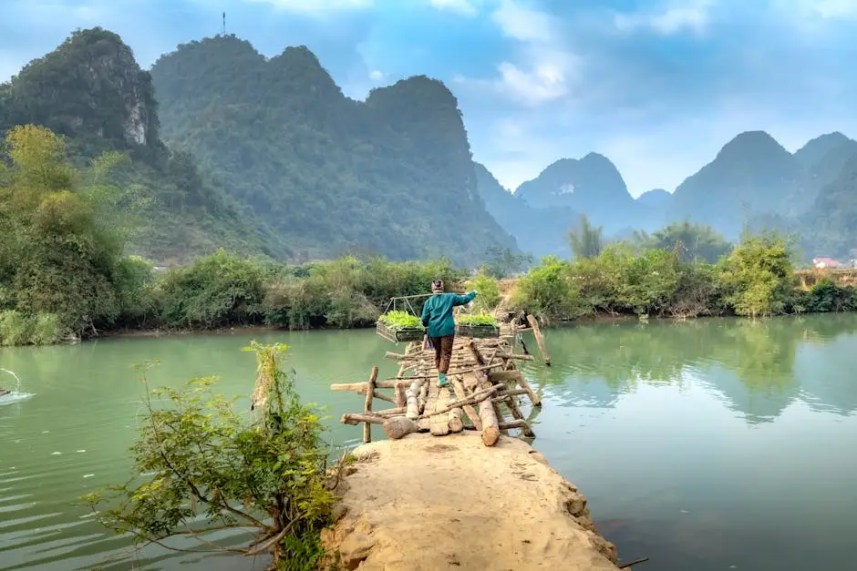 A Person Walks On A Wooden Bridge Over A Tranquil River With Stunning