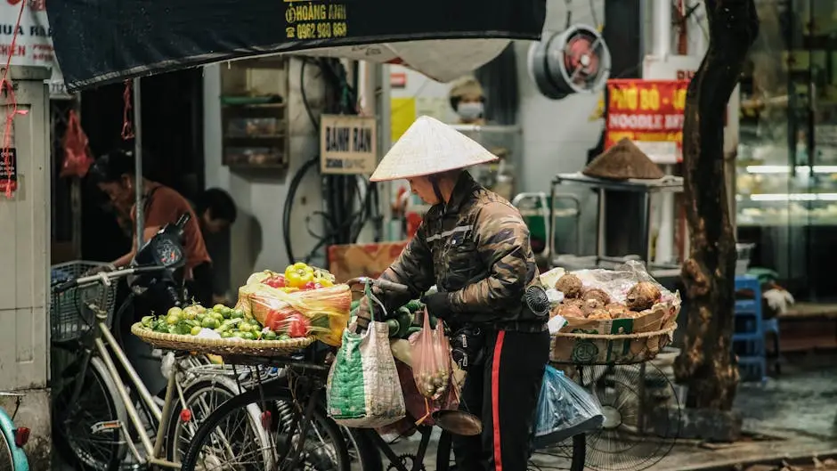 a_vendor_in_hanoi_s_street_market_with_traditional_hat_selling_vegetab.webp