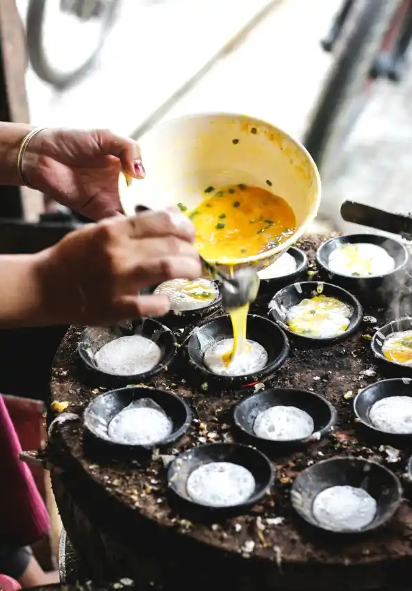 cooking traditional banh can street food