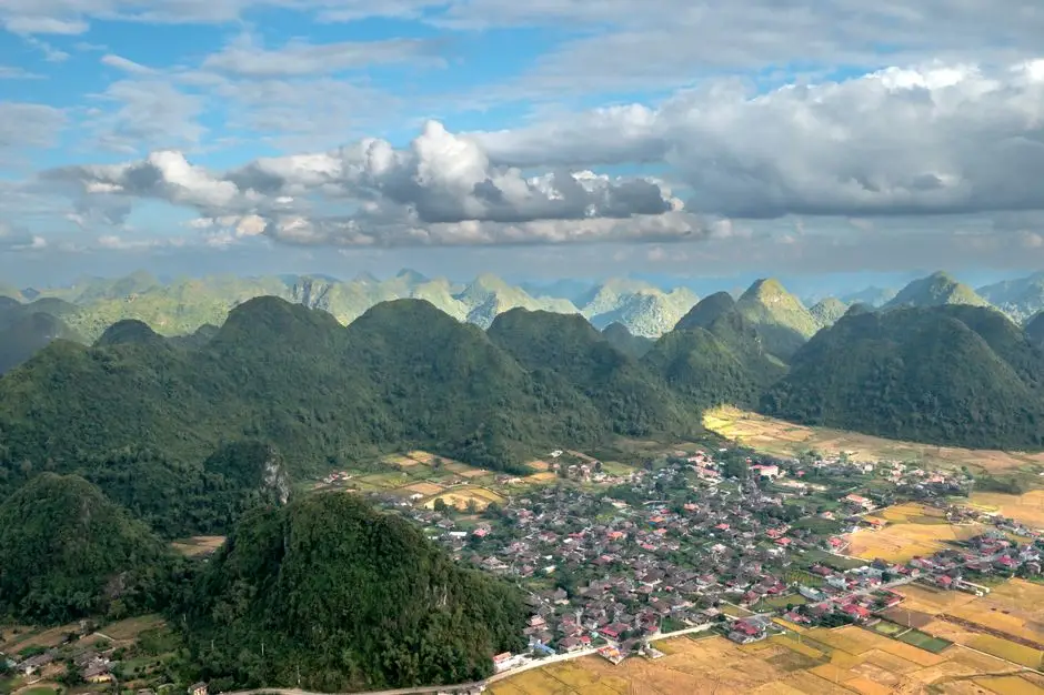 Stunning Aerial View Of A Rural Village Surrounded By Lush Green Mount