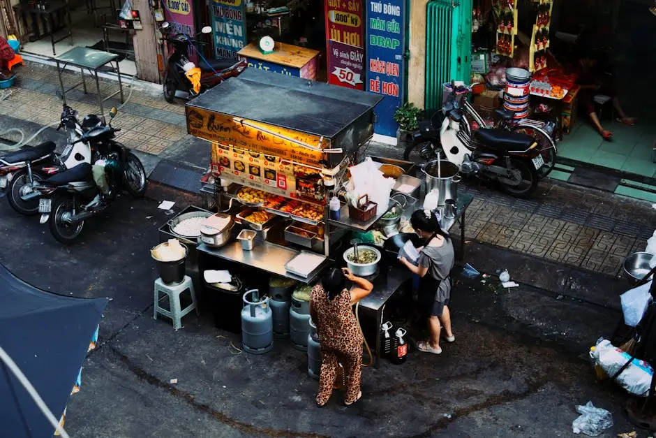 Two Women Preparing Food At A Bustling Vietnamese Street Food Stall