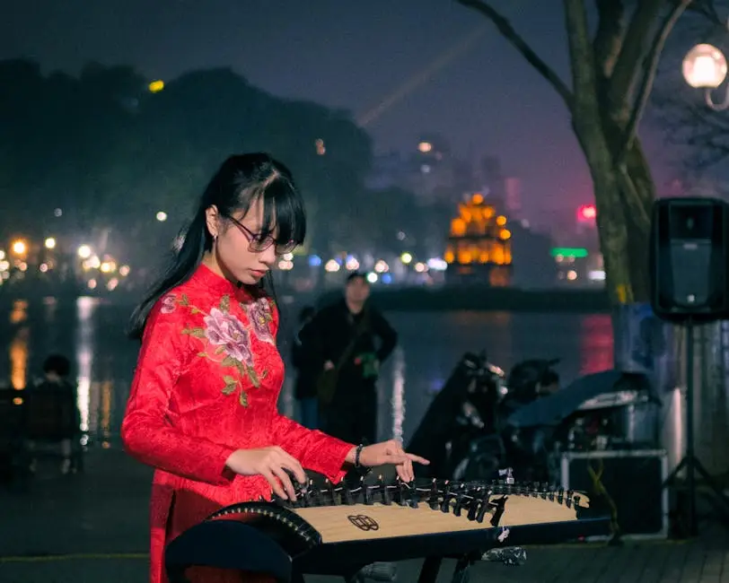 Woman In Traditional Dress Plays Vietnamese Instrument At Hoan Kiem La
